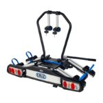Nosač za električne bicikle za kuku maksimalne nosivosti 60 kg. Nagibni uz pomoć pedale za brz i jednostavan pristup prtljažniku. Stražnja svjetla.