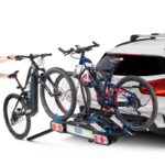 Nosač za električne bicikle za kuku maksimalne nosivosti 60 kg. Nagibni uz pomoć pedale za brz i jednostavan pristup prtljažniku. Stražnja svjetla.