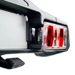 Nosač za električne bicikle za kuku maksimalne nosivosti 60 kg. Nagibni uz pomoć pedale za brz i jednostavan pristup prtljažniku. Stražnja svjetla.